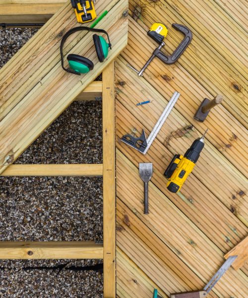 Deck tools and deck under construction Top down image of a desk under construction showing joists, planks and tools used