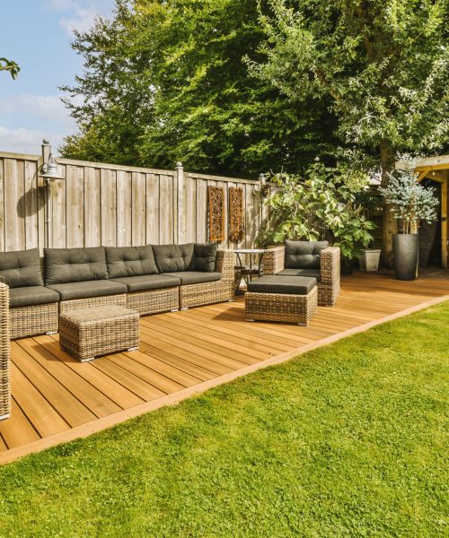 Neat patio with sitting area Neat paved patio with sitting area and small garden near wooden fence