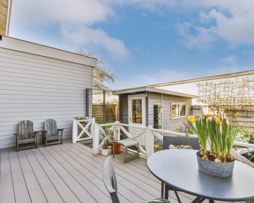 Neat patio with sitting area Neat paved patio with sitting area and small garden near wooden fence